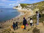 Chilly Britons light FIRES and pull on woolly socks as temperatures plunge but crowds flock to beach