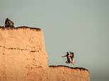 Moment two women risk their lives for photo on top of 400ft cliffs prone to massive rock falls 