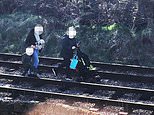 Police release photo of two women walking with pram and toddler along LIVE train line