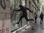 Riot police spray tear gas as they come under attack from protesters in Paris