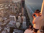 Daredevils risk death as they are spotted taking videos from the top of Australia’s tallest building