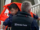 Border Force official carries screaming boy to safety after packed migrant boat is intercepted