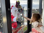Santa swaps his sleigh for a CRANE to visit sick children in hospital