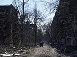 As the Russians roll in, one lone family strolls in Mariupol’s ruins