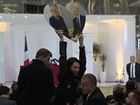 Woman thrown to floor and dragged away by Marine Le Pen’s security guards for holding up Putin sign