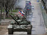 Russian tanks roll in to Mariupol: Columns fly flags from their turrets as they patrol ruins
